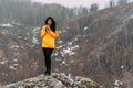 Traveler holding a mug of hot tea in the mountains. Woman in sportswear in the mountains. Climb to the top of the mountain. Girl