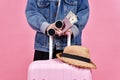 Traveler holding pink suitcase, Passenger and passport document over pink background. Royalty Free Stock Photo