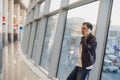 Traveler inside airport terminal. Young man using mobile phone and waiting for his flight. Royalty Free Stock Photo