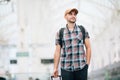 Traveler is late at the train station. Young man with backpack and suitcase missed the train and waiting for next Royalty Free Stock Photo