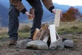 Traveler making bonfire with dry wood outdoors, closeup