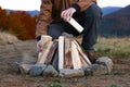 Traveler making bonfire with dry wood outdoors, closeup