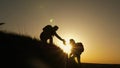 Traveler man extends his hand to a girl climbing to the top of a hill. travelers climb the cliff holding hand. teamwork Royalty Free Stock Photo