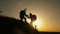 Traveler man extends his hand to a girl climbing to the top of a hill. travelers climb the cliff holding hand. teamwork Royalty Free Stock Photo