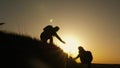 Traveler man extends his hand to a girl climbing to the top of a hill. travelers climb the cliff holding hand. teamwork Royalty Free Stock Photo