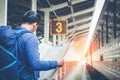 Traveler man with map and waits train on railway platform