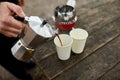 Traveler man pouring fresh hot coffee from geyser coffee maker into cup outdoor Royalty Free Stock Photo