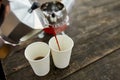 Traveler man pouring fresh hot coffee from geyser coffee maker into cup outdoor Royalty Free Stock Photo