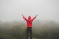 Traveler Man raised hands standing on cliff mountains adventure travel lifestyle concept summer vacations Royalty Free Stock Photo