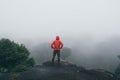 Traveler Man raised hands standing on cliff mountains adventure travel lifestyle concept summer vacations Royalty Free Stock Photo