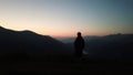 Traveler Man relaxing standing and enjoying serene view mountains landscape at sunrise. Royalty Free Stock Photo