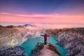 Traveler man standing on the crater of Kawah Ijen volcano with sunrise sky in the morning Royalty Free Stock Photo