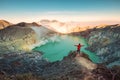 Traveler man standing on the crater of Kawah Ijen volcano with sunrise sky in the morning Royalty Free Stock Photo