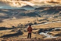 Traveler man standing on volcanic mountain and sunset sky in Icelandic Highlands on summer at Iceland