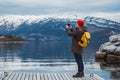 Traveler man taking photo with smartphone on mountains. Tourist in yellow backpack standing on a background of a Royalty Free Stock Photo