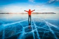 Traveler man wear red clothes and raising arm standing on natural breaking ice in frozen water at Lake Baikal, Siberia, Russia