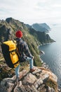 Professional expeditor standing on the edge cliff rock and looking forward away. Wanderlust