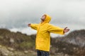 Man in yellow raincoat in the clouds mountains in stormy weather with rain Royalty Free Stock Photo