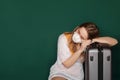 Traveler with a medical mask on face is waiting for flight due to a coronavirus Royalty Free Stock Photo