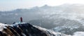 Traveler with a backpack on top of snow mountains