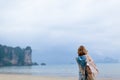 Traveler and photographer pretty woman in long dress is taking photo of tropical seascape on beautiful ocean beach Royalty Free Stock Photo