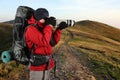 Traveler photographer in a red jacket takes pictures of nature