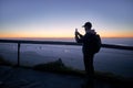 Traveler photographing beautiful landscape by phone