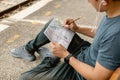 Traveler is planning vacation and looking the map at railway station. Man is writing notes and pointing on the map Royalty Free Stock Photo