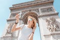 Traveler playing with a toy airplane on the background of the arc de Triomphe. The concept of low-cost and cheap airline