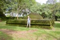 A traveler poses next to a large dome of an old building in Polonnaruwa