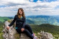 Traveler posing on rocks in the background of Rarau Mountains, Romania