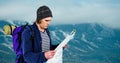 Traveler reading map while carrying backpack on mountain Royalty Free Stock Photo