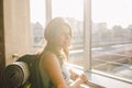 Traveler Rear view woman standing at the window in hall Train Station departure with backpack , Selective focus, Travel