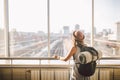 Traveler Rear view woman standing at the window in hall Train Station departure with backpack , Selective focus, Travel