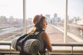 Traveler Rear view woman standing at the window in hall Train Station departure with backpack , Selective focus, Travel