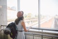 Traveler Rear view woman standing at the window in hall Train Station departure with backpack , Selective focus, Travel