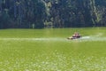 Traveler relaxing on bamboo raft in brigt lake