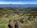 Traveler resting on the mountain, legs in hiking boots close-up, wonderful view on mountain landscape Royalty Free Stock Photo