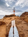 Traveler resting on the rocky land near the lighthouse Royalty Free Stock Photo