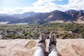 Traveler`s boots relaxing and resting his feet on high mountain trekking and ancient town scene and adventure