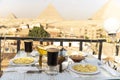 Traveler\'s breakfast. A table in an outdoor restaurant with a fantastically beautiful view of the great pyramids of Giza. Cairo.