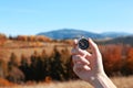 Traveler searching direction with compass in wilderness, closeup Royalty Free Stock Photo