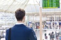 Traveler sending text message on smartphone in train station