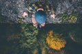 Traveler sitting on cliff bridge edge with forest aerial view