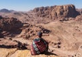 Traveler sitting on edge of mountain cliff, at Wadi Rum desert in Jordan. Travel lifestyle and adventure and journey