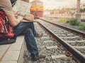 Traveler sitting and looking at the map in train station. Royalty Free Stock Photo