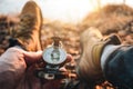 Traveler sitting near lake and hold compass in hand and search way. POV view Royalty Free Stock Photo