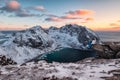 Traveler sitting on Ryten mountain with Kvalvika beach on sunset at Lofoten islands