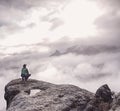 Traveler sitting on the sandstone cliff. Rear view of male hiker Royalty Free Stock Photo