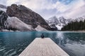 Traveler sitting on wooden pier with rocky mountain in Moraine lake at Banff national park Royalty Free Stock Photo